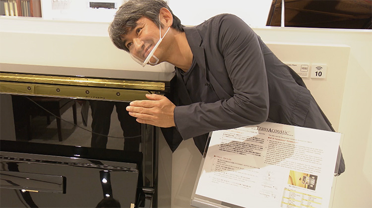 Mizuguchi smiles as he experiences the sound vibration of the piano.